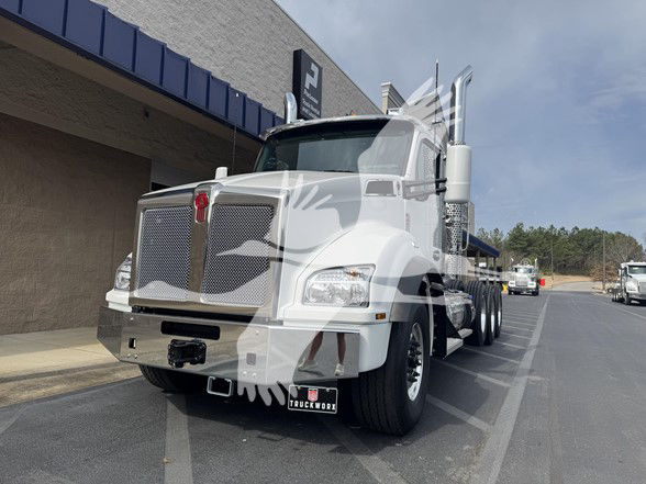 Kenworth T880 conventional daycab truck in white, front-side view showing chrome grille, tall exhaust stacks, and large bumper.