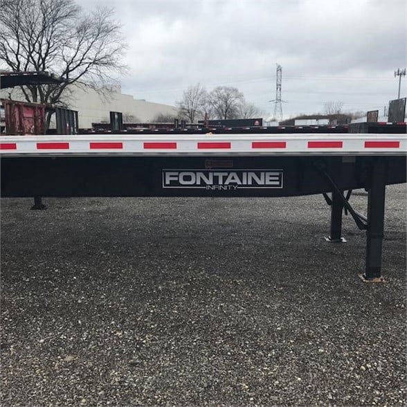 Flatbed trailer with Fontaine Infinity logo on the side rail showing stock number 562433 and Fontaine Infinity branding.