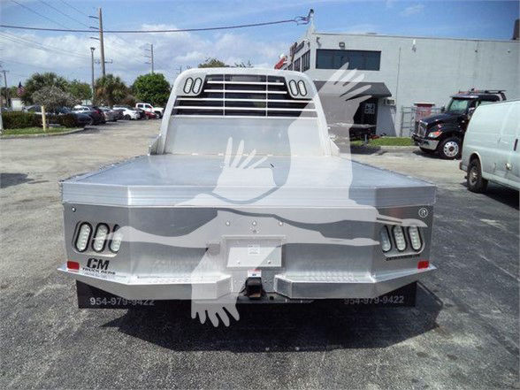 2023 Ram 5500 SLT flatbed rear view showing tail lights, bumper, and CM truck bed with dealer watermark.