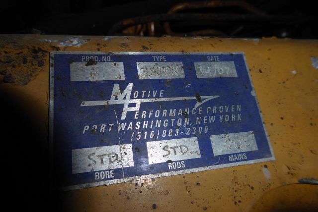 Plate showing Motive Power Performance plaque with fields: PROD NO, TYPE, DATE; STD BORE, RODS, MAINS; text 'Motive Power Performance Proven Portland Washington New York' and a phone number. The surrounding area is a yellow engine housing w