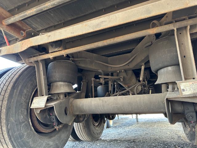 Trailer undercarriage showing rear axle suspension, air springs, dual tires, and frame members of a 2015 Utility 4000DX roll door trailer.