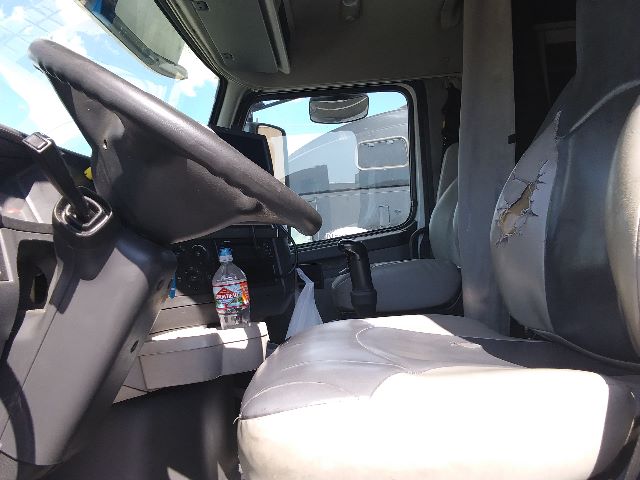 Volvo 670 truck interior showing driver seat and steering wheel with cracked seat and a water bottle in cup holder.