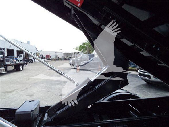 Isuzu NRR truck engine bay with open hood showing windshield supports and some exterior equipment; silhouetted overlay image of hands and bird graphic.