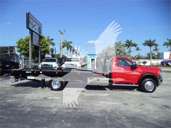 Ram 5500 tow truck with red cab and black flatbed viewed in side profile.