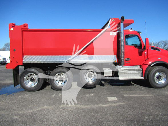 Kenworth T880 dump truck side view showing red dump body, chrome wheels, and silver step plates.