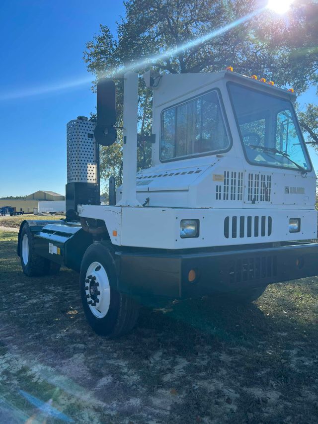 2012 Ottawa 4x2 CNG truck cab with vertical exhaust stacks, front grille and white body. Visible text on side includes 'OTTAWA' and some branding near cab. Vehicle is on a dirt lot.