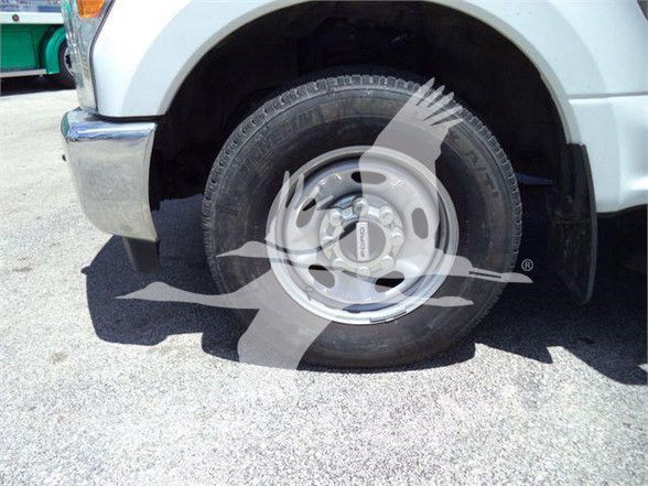 Ford F-250 front wheel showing steel wheel and tire in vehicle’s front fender well.