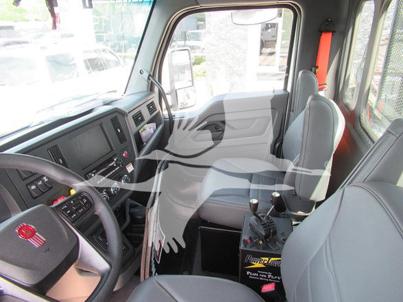 Kenworth T480 cab interior showing driver seat, passenger seat, steering wheel, and dashboard with controls.
