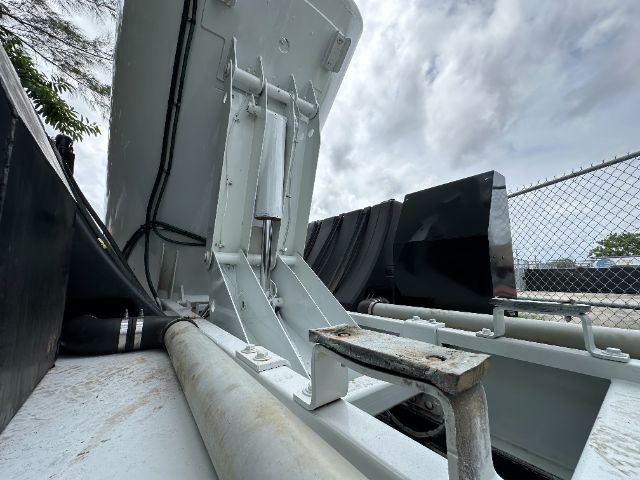 Truck equipment mounting hardware and metal beam with hydraulic cylinder showing a tailgate or hoist mechanism on a Peterbilt truck body.