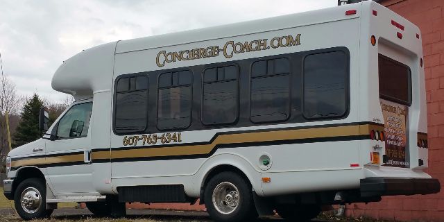 Ford E-450 bus exterior showing Concierge Coach branding and service windows.