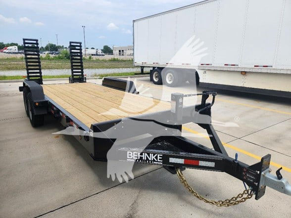 Behnke flatbed trailer in a parking lot showing gooseneck hitch and wooden deck.