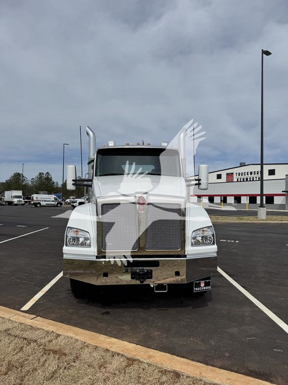 Kenworth T880 front view showing large chrome grille and bumper in a parking lot.