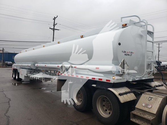 Hauled tank trailer showing a large cylindrical 9200 gallon trough bottom petro tanker with white paint and markings. rear right shows KB/KEP27 label and 1-24-1-24  KEPA 27 text near end cap.
