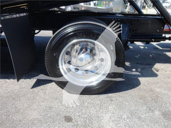 Wheel and hub of a Freightliner M2 chassis with chrome rim and tire in a truck bed, visible undercarriage and frame.
