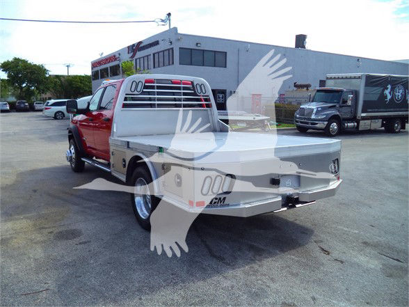 Ram 5500 SLT pickup with flatbed, rear view showing tailgate and Chevrolet-like badge, in a dealership lot.