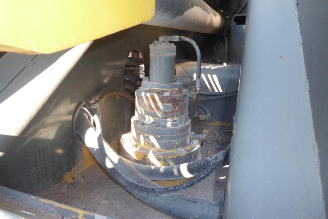 Hydraulic component and mounting base in Grove T60 boom lift showing hydraulic fitting and hose in an industrial bay.