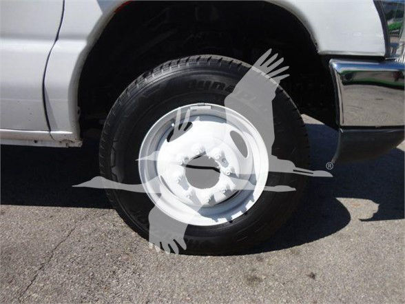 Ford E-450 wheel/tires showing front passenger side wheel with white hubcap; watermark across image.