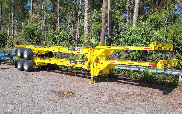 Yellow Stoughton 40' intermodal heavy duty chassis trailer on a gravel lot with trees in background showing dual rear axles and support jack.