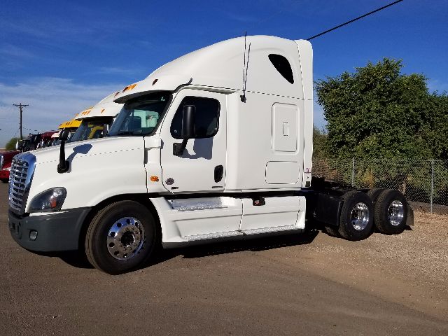 2012 Freightliner Cascadia conventional sleeper truck side view with white cab and dual rear axles.
