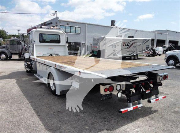 MD6 tow truck flatbed with wood deck and rear towing equipment visible in a dealership lot.
