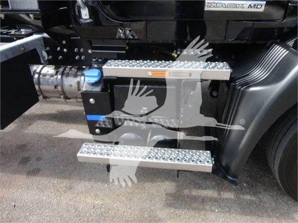 Truck step platform and fuel/air hoses mounted beside cab on a Mack MD front portion showing metallic diamond plate steps and a blue capped reservoir.