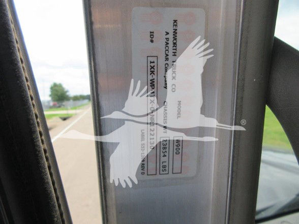 Kenworth W900L truck label on door jamb showing vehicle identification information. Visible text includes 'KENWORTH TRUCK CO', 'A PACCAR COMPANY', 'ID', '1XKWP4TX1NR130317', 'RS', and other small alphanumeric details on a sticker.