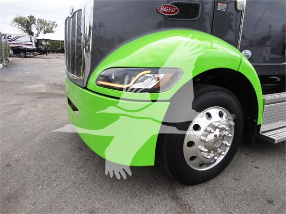 Front left side of a bright green Peterbilt 337 truck, wheel and headlamp visible, Peterbilt emblem on grille.