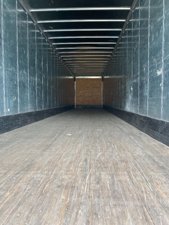 Interior of a 2015 Wabash Duraplate trailer showing wooden floor and metal side walls with greenish tint.