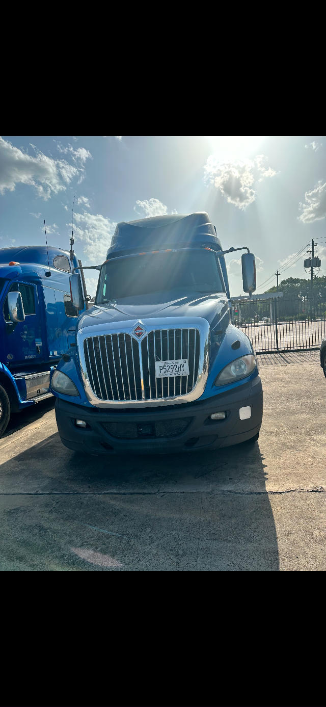 Front view of a blue 2017 International ProStar semi-truck with chrome grille, large vertical bars, and a raised sleeper cab. License plate visible on the grille area.
