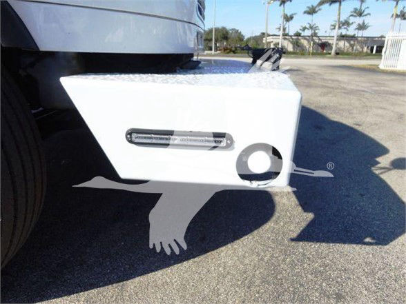 Freightliner business class M2 106 side view showing front bumper/integrated step plate and fog light area.