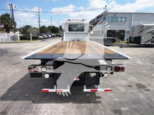 Mack MD6 tow truck flatbed rear view with wooden bed and rear lights visible.
