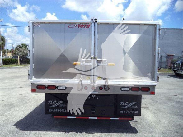 Truck dump bed back view with silver enclosed cargo box, chevrolet logo not visible, rear lights, and TLC branding on bumper area.
