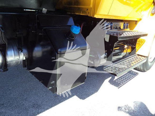 Truck underbody area showing a large black rectangular fuel tank with a blue filler cap and steps of the cab on the right; isometric watermark graphics overlaid.
