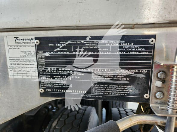 Transcraft trailer identification plate with VIN 1TTF482C8N3325686 and various specs; metal plaque mounted on trailer frame with bolts.