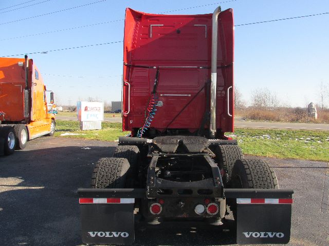 Volvo 780 conventional sleeper truck chassis rear view showing dual rear axles, red cab, and Volvo mud flaps.