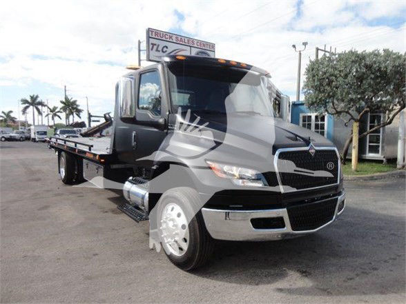 International MV truck with a flatbed, black cab, chrome front bumper, and large side mirrors. VIN and stock number not visible on image.