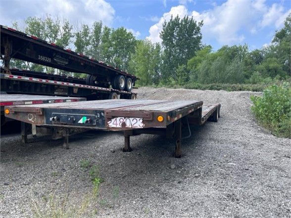 Dynaweld steel stepdeck trailer showing rear with license plate area, level deck, and support legs extended.