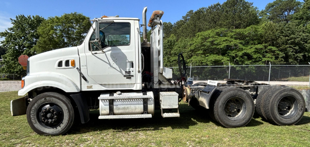 Sterling LT9500 cab and chassis truck side view showing front wheel, fuel tank, and mated rear axle with dual tires.