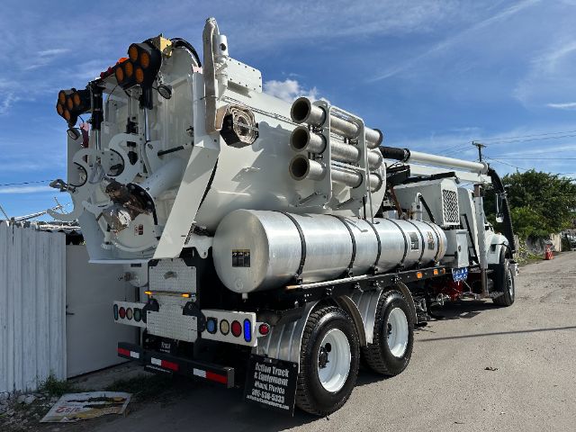 Vacuum truck chassis with multiple cylindrical tanks and hoses mounted, International 7500 model, rear view.