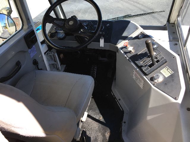 Kalmar Ottawa YT30 operator cab showing steering wheel, control levers, and front dashboard with pedals.
