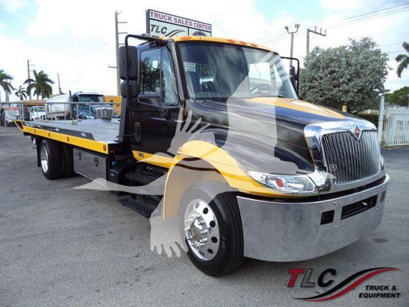 2019 International DURASTAR 4300 tow truck with flatbed, black and yellow color scheme, front chrome bumper, large grille, and TLC Truck & Equipment watermark.