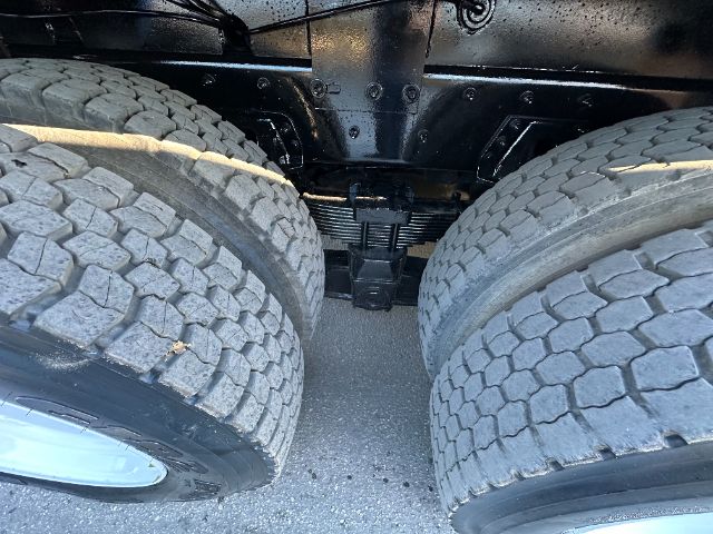 Sterling L7500 truck undercarriage showing dual rear axles with large off-road tires and leaf spring suspension.