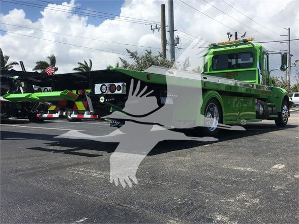 Green 2022 Peterbilt 337 tow truck side view showing flatbed and rear controls.
