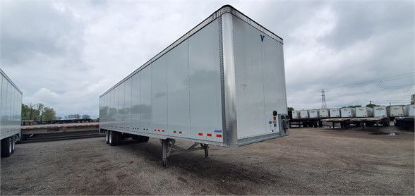 Vanguard VXP dry van trailer showing long rectangular cargo box with front nose uplift and tandem axles in a dealership lot.