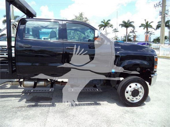 Truck side view showing International CV truck with black cab and crew cab, front wheel visible, stock number CV515CREW14SNG2.