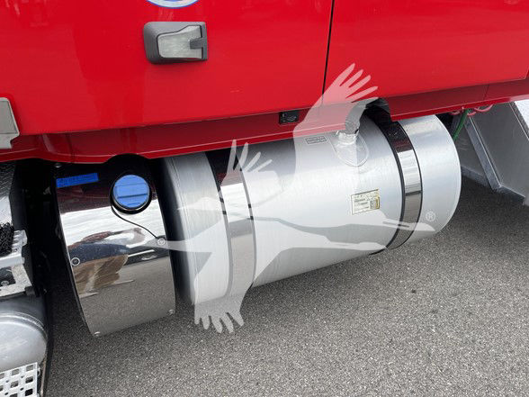 Volvo VNL64T740 truck fuel tank area showing cylindrical polished aluminum fuel tanks and chrome exterior, with blue cap visible.