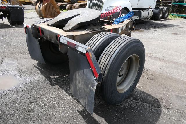 Fruehauf ELFI trailer dolly rear view showing dual rear tires, mud flaps, and hydraulic hoses with metal guards.