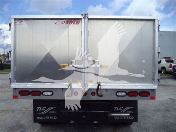 Ford F-550 truck bed rear view showing aluminum dump body with Voth logo and TLC mudflaps.