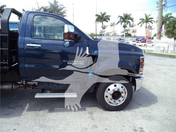 Chevrolet Silverado 6500 HD side view showing cab and front wheel, with 'SILVERADO 6500 HD' badge on the front door area. Step bar visible under the door.