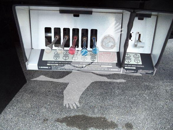 Rear view showing multi-valve control panel with colored knobs (silver, red, pink, blue) and warning labels on a Peterbilt truck air system.